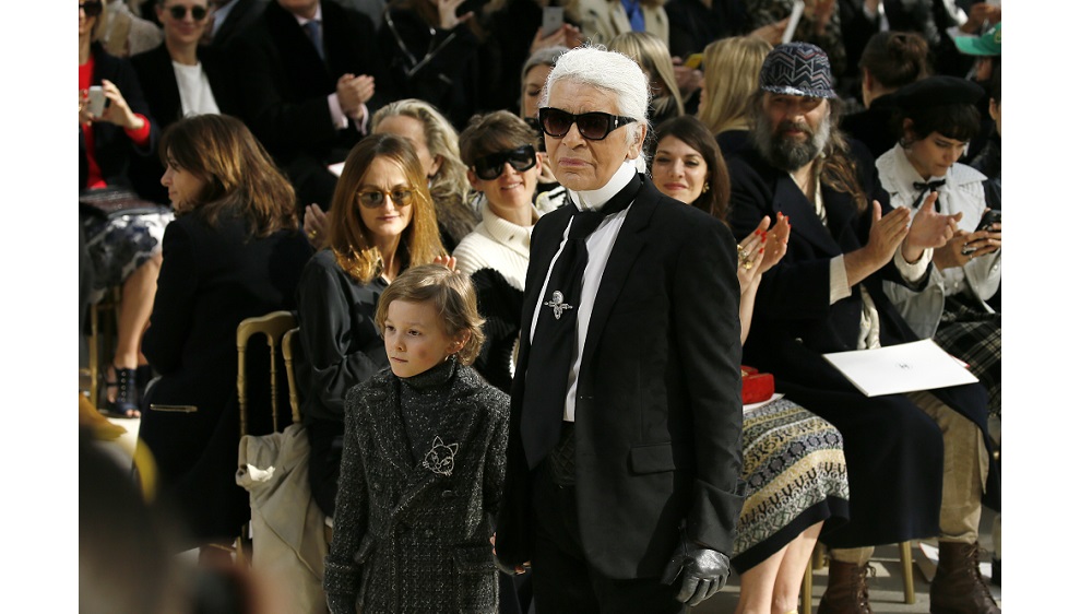 German designer Karl Lagerfeld and model Hudson Kroenig appear at the end of his Fall/Winter 2016/2017 women’s ready-to-wear collection for fashion house Chanel at the Grand Palais in Paris