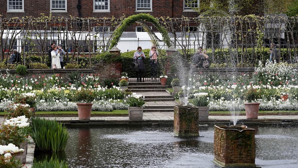 Visitors look at the Princess Diana memorial garden at Kensington Palace in London
