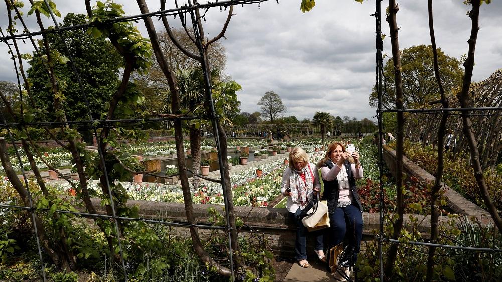 Visitors take a selfie at the Princess Diana memorial garden at Kensington Palace in London