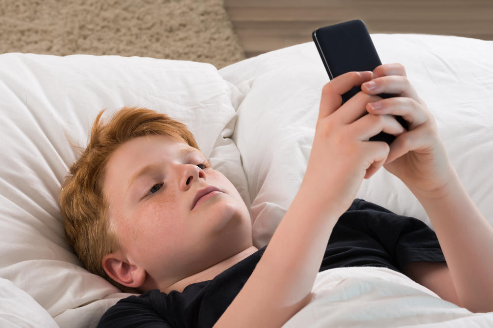4 Criança smartphone cama