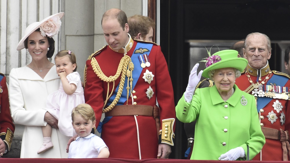 Members of the royal family, including Catherine, Duchess of Cambridge holding Princess Charlotte, Prince George, Prince William, Queen Elizabeth, and Prince Philip stand on the balcony of Buckingham Palace in central London