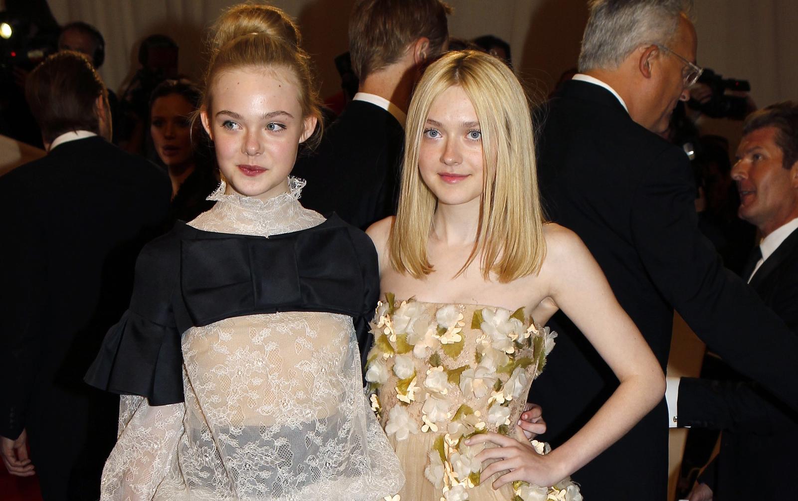 Elle Fanning and Dakota Fanning pose on arrival at the Metropolitan Museum of Art Costume Institute Benefit celebrating the opening of Alexander McQueen: Savage Beauty, in New York