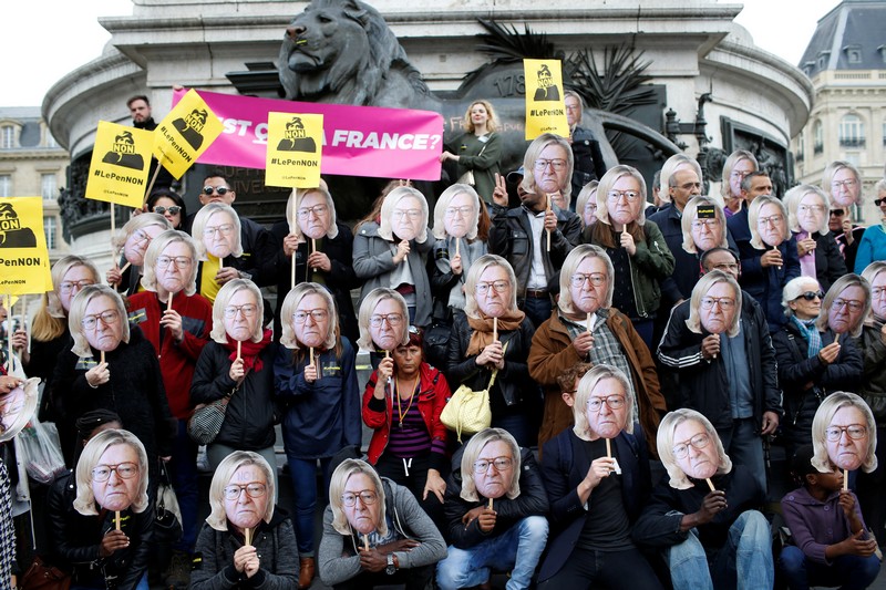 Activists wear masks depicting the face of Jean-Marie Le Pen, the founder of the French far-right National Front, with the hair of his daughter Marine Le Pen during a demonstration as part of traditional May Day labour day march in Paris