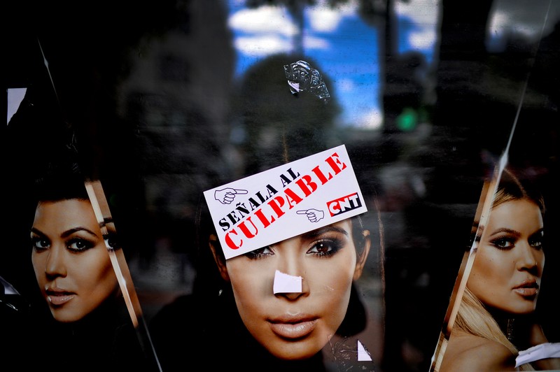 A sticker from anarcho-syndicalist trade union CNT, reading “Point To The Guilty”, is stuck onto a poster advertising the reality television program “Keeping Up With The Kardashians” during May Day labour day marches in Bilbao