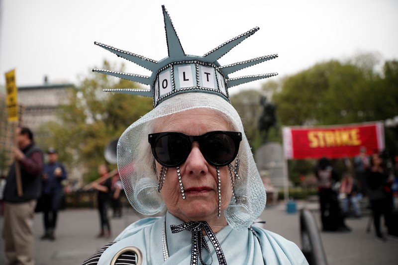 A woman stands dressed as the Statue of Liberty during a May Day protest in New York