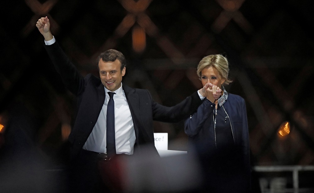 Emmanuel Macron e a mulher Brigitte Trogneux celebrando a vitória
