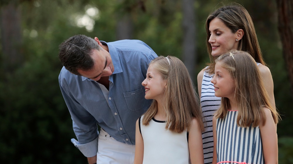 Spain’s King Felipe looks at his daughter Princess Leonor as they pose with Queen Letizia and Princess Sofia during a photocall in the gardens of the Marivent Palace in Palma de Mallorca