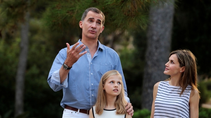 Spain’s King Felipe gestures as he poses with Queen Letizia and their daughters Princess Leonor and Princess Sofia during a photocall in the gardens of the Marivent Palace in Palma de Mallorca
