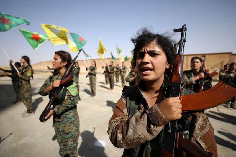 Syrian Democratic Forces female fighters hold their weapons during a graduation ceremony in the city of Hasaka