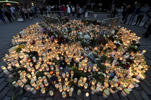 Memorial cards, candles and flowers for the victims of Friday's stabbings are placed on the Market Square in Turku