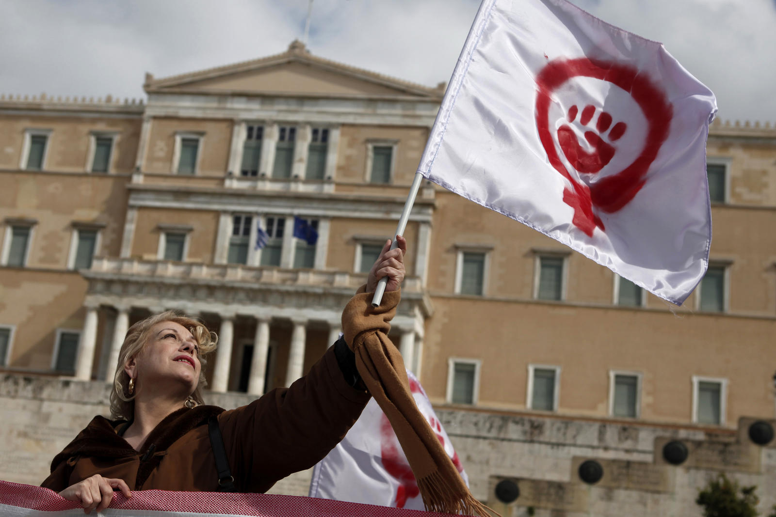 A woman waves a flag depicting a symbol of feminism during a march to celebrate International Women’s Day in Athens