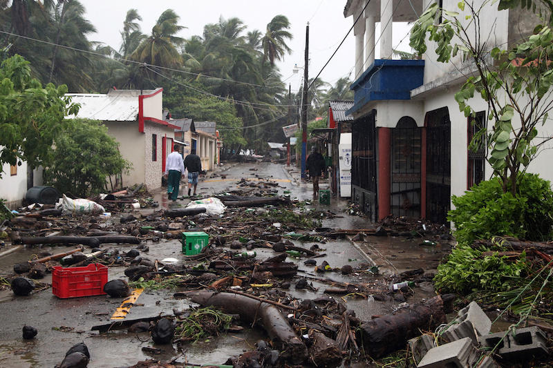 People walk on a street covered in debris as Hurricane Irma moves off from the northern coast of the Dominican Republic, in Nagua