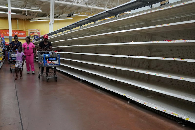 People walk past empty shelves where bread is normally sold in a Walmart store in advance of Hurricane Irma’s expected arrival in North Miami Beach