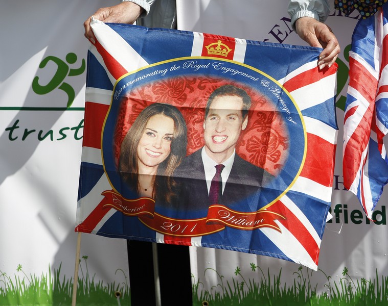A woman holds a flag as Britain’s Prince William and his fiancee Kate Middleton visit the Witton Country Park in Darwen