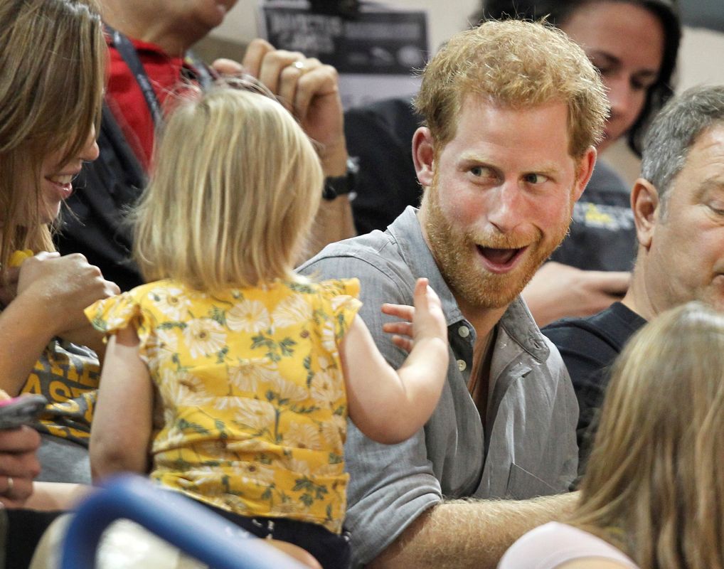 Britain’s Prince Harry, patron of the Invictus Games Foundation, shares popcorn with a child while attending the Sitting Volleyball competition at the games in Toronto