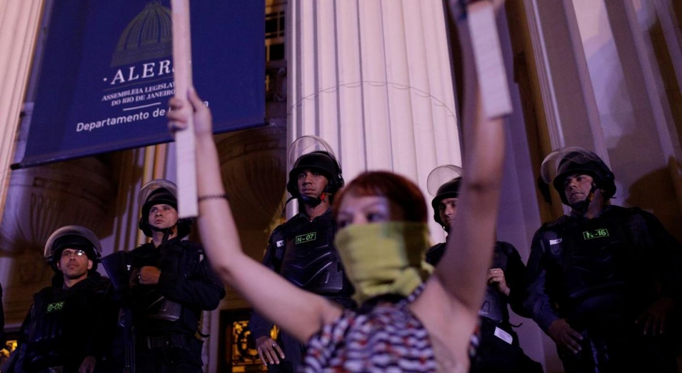 Riot policemen observe as protesters demonstrate against Brazil’s congressional move to criminalize all cases of abortion, including cases of rape and where the mother’s life is in danger, in Rio de Janeiro
