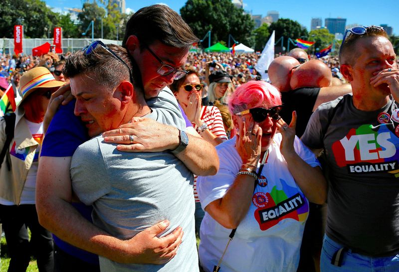 People celebrate after it was announced the majority of Australians support same-sex marriage in a national survey, at a rally in Sydney