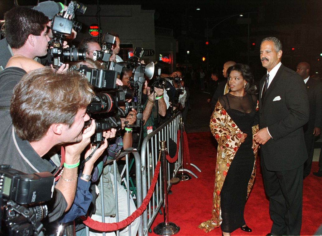 Actress Oprah Winfrey star of the new film “Beloved”  is escorted up the red carpet by her companion..