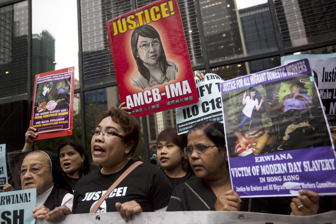 Supporters hold signs of Indonesian domestic helper Erwiana Sulistyaningsih, during a protest calling for better protection of migrant workers, in Hong Kong