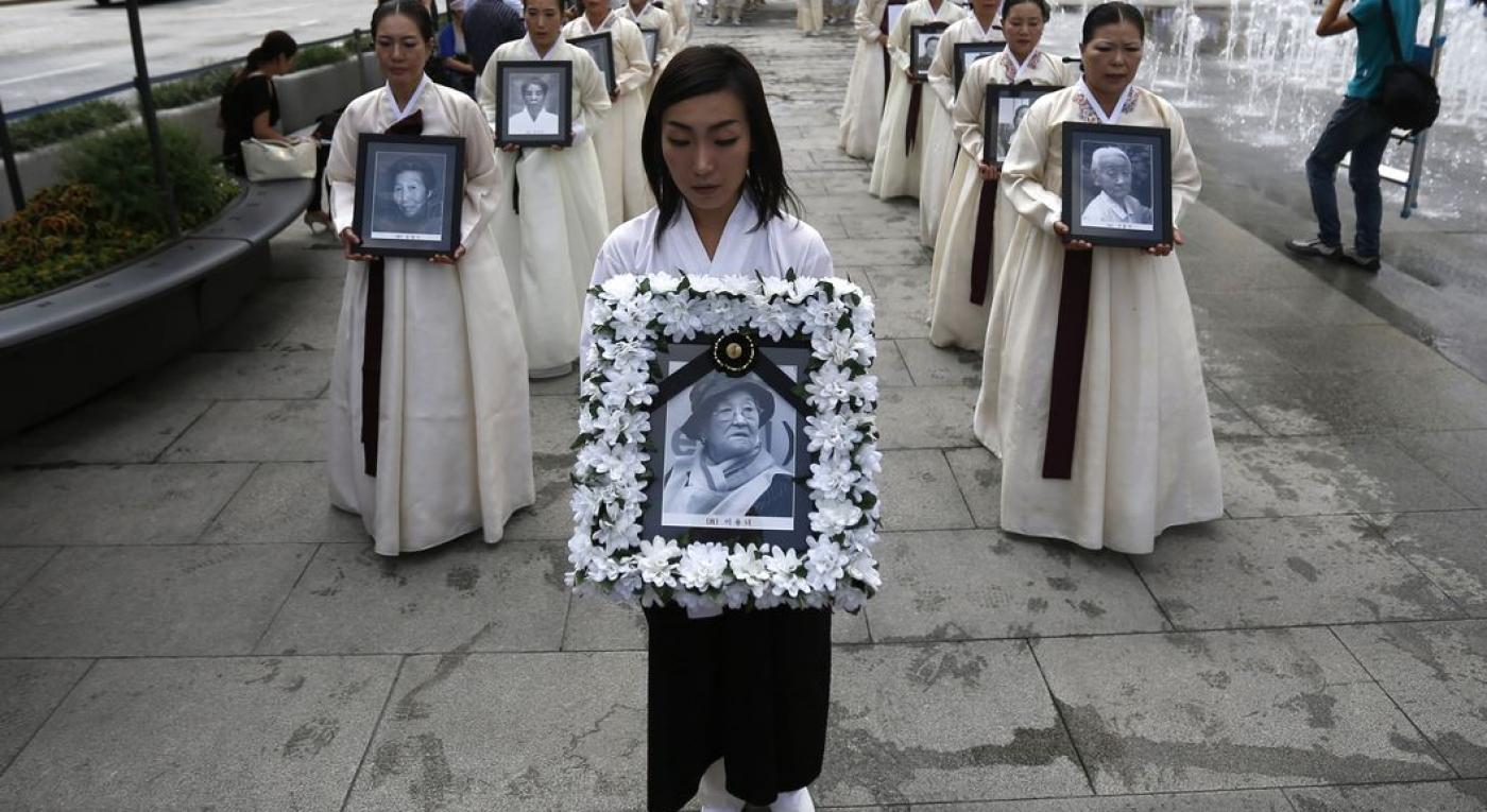 Participants carry the portraits of Korean women who were made sex slaves by the Japanese military during World War II, during a requiem ceremony for former comfort woman Lee Yong-nyeo in central Seoul
