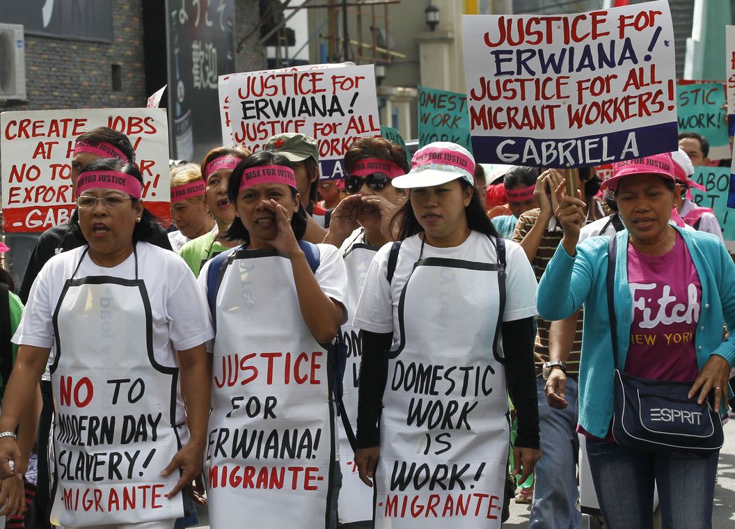 Protesters display placards demanding justice for Indonesian domestic helper Erwiana during a march in Manila