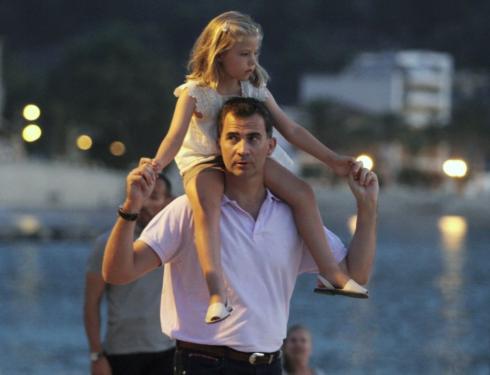 Spain’s Crown Prince Felipe carries his daughter Leonor while going for a walk in Port de Soller, on the Spanish Balearic island of Mallorca