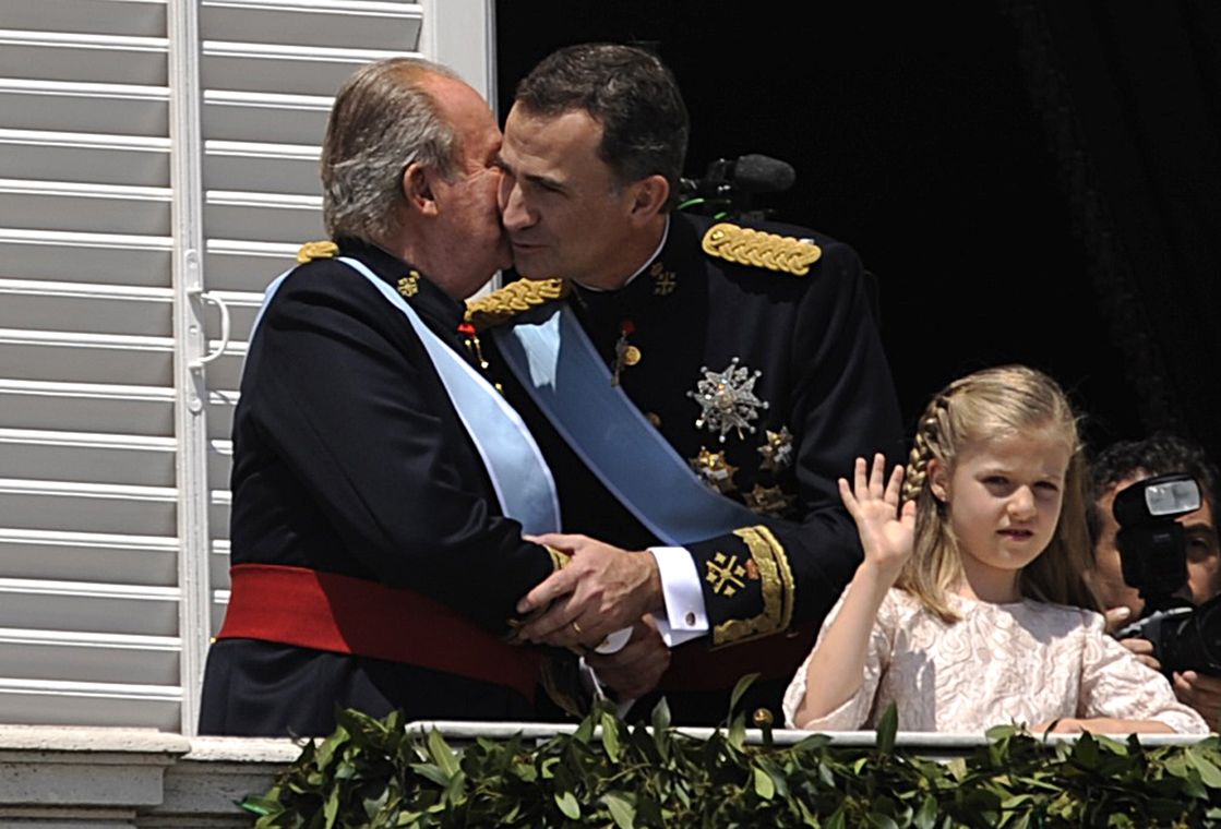 Spain’s new King Felipe VI and King Juan Carlos embace as Princess Leonor waves on the balcony of the Royal Palace in Madrid