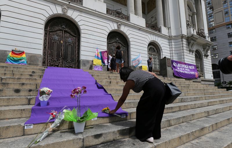 A demonstrator places flowers before the wake of councilwoman Marielle Franco, 38, who was shot dead, in Rio de Janeiro