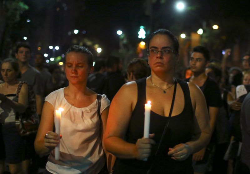 People hold candles to mourn Rio de Janeiro’s city councillor Marielle Franco, 38, who was shot dead, outside the city council chamber in Rio de Janeiro