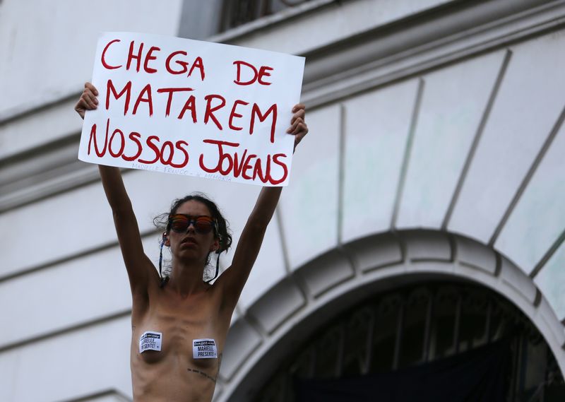 A woman holds a sign during a protest for the Rio de Janeiro’s city councillor Marielle Franco, who was shot dead, outside the city council chamber in Rio de Janeiro