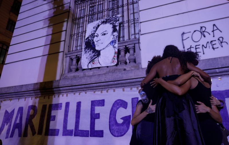Demonstrators react next to a draw representing the Rio de Janeiro city councilor Marielle Franco who was shot dead in Rio de Janeiro, during a rally against her death Brazil