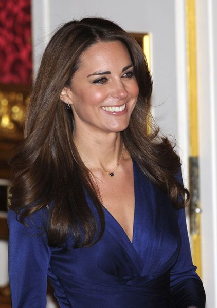 Kate Middleton enters a room with her fiance, Britain’s Prince William, to pose for a photograph in St. James’s Palace