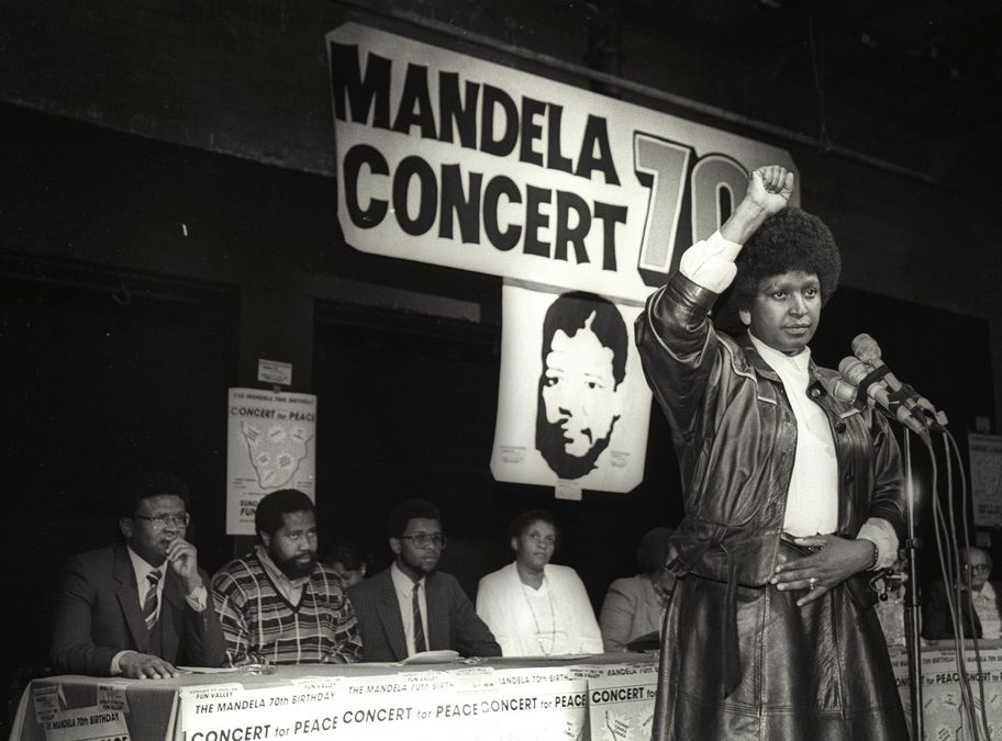 Winnie Mandela raises her fist after announcing massive pop concert will be held to mark the 70th birthday of Nelson Mandela