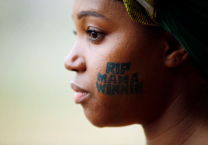 A woman watches the funeral servce for Winnie Madikizela-Mandela at the Orlando stadium in Soweto