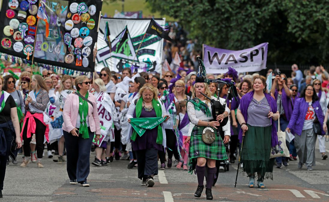 Women wear the suffragette colours of green, white and violet – standing for Give Women Votes – as they take part in the ‘Processions’ women’s march in Edinburgh
