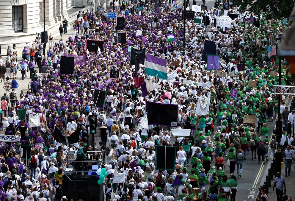 Women wear coloured clothes and march in a colour coordinated way to show the suffragette colours of green, white and violet – standing for Give Women Votes – in the ‘Processions’ women’s march in London