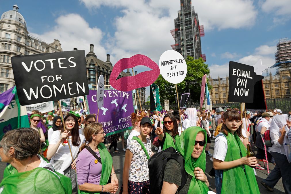 Women wear the suffragette colours of green, white and violet – standing for Give Women Votes – in the ‘Processions’ women’s march in Westminster, London