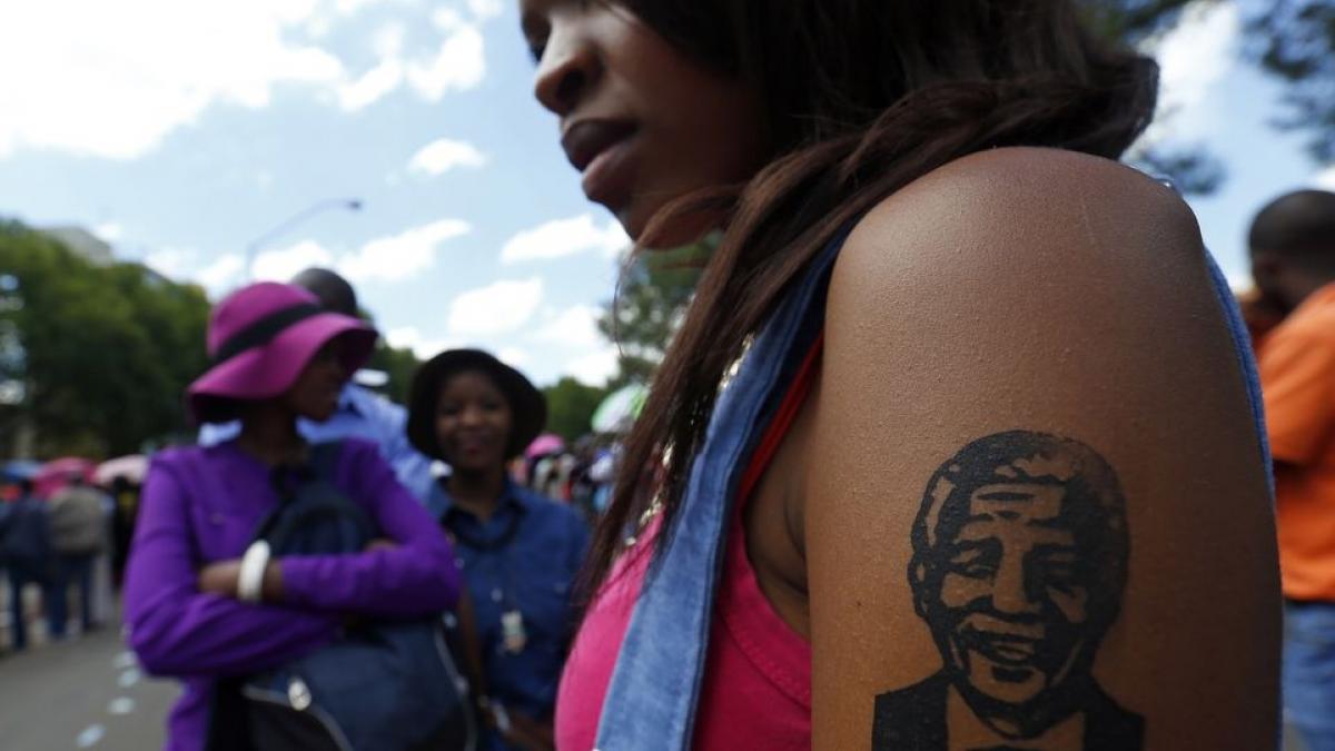 Woman displays a fake tattoo depicting the portrait of former South African President Nelson Mandela in Pretoria