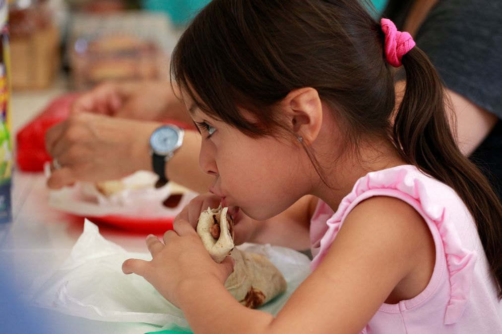 A girl eats a burrito during breakfast at a restaurant in Ciudad Juarez