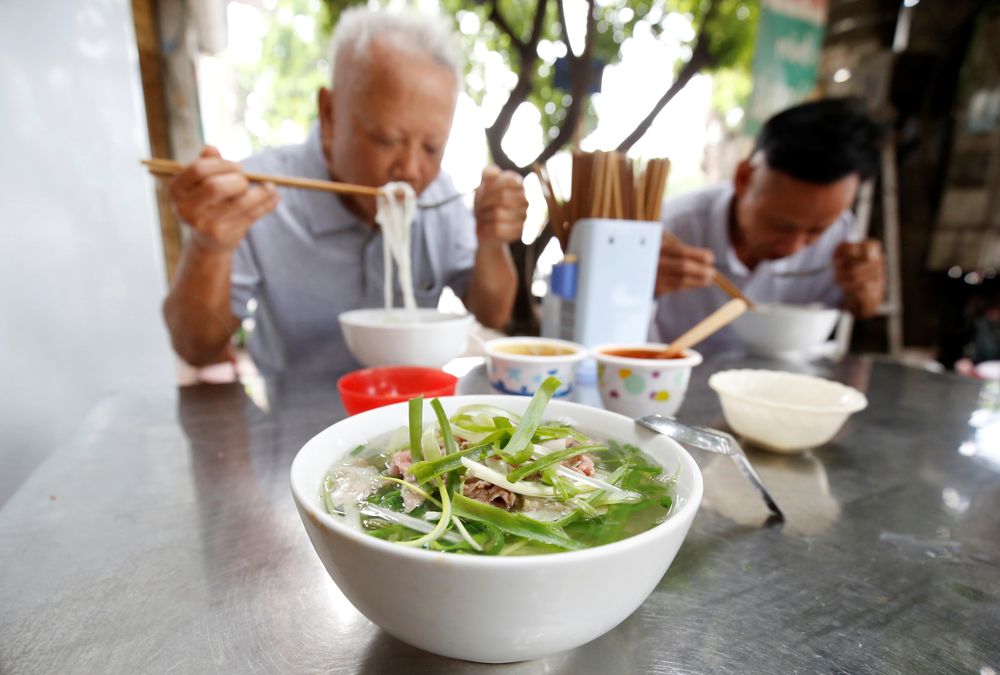 Poeple eat the Vietnamese traditional beef noodle “Pho” at a breakfast restaurant in Hanoi