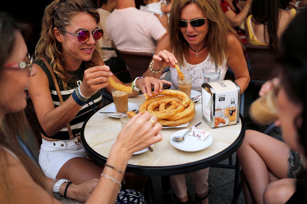 Women have breakfast with traditional Spanish “Churros” at the “Churreria and coffee shop El Corralillo” in downtown Ronda