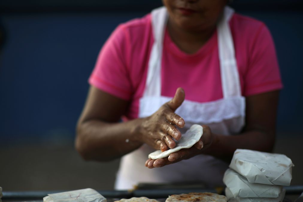 A woman prepares Pupusas, a traditional Salvadoran dish, at El Salvador del Mundo Square in San Salvador