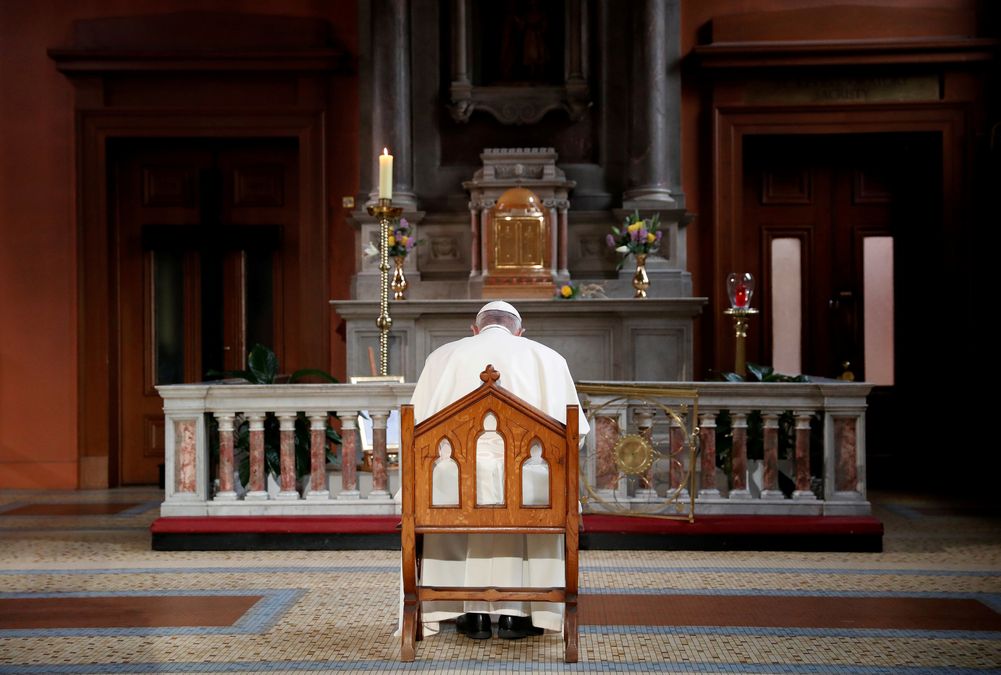 Pope Francis prays in front of a candle lit to remember victims of abuse by the church, inside St Mary’s Pro Cathedral during his visit to Dublin