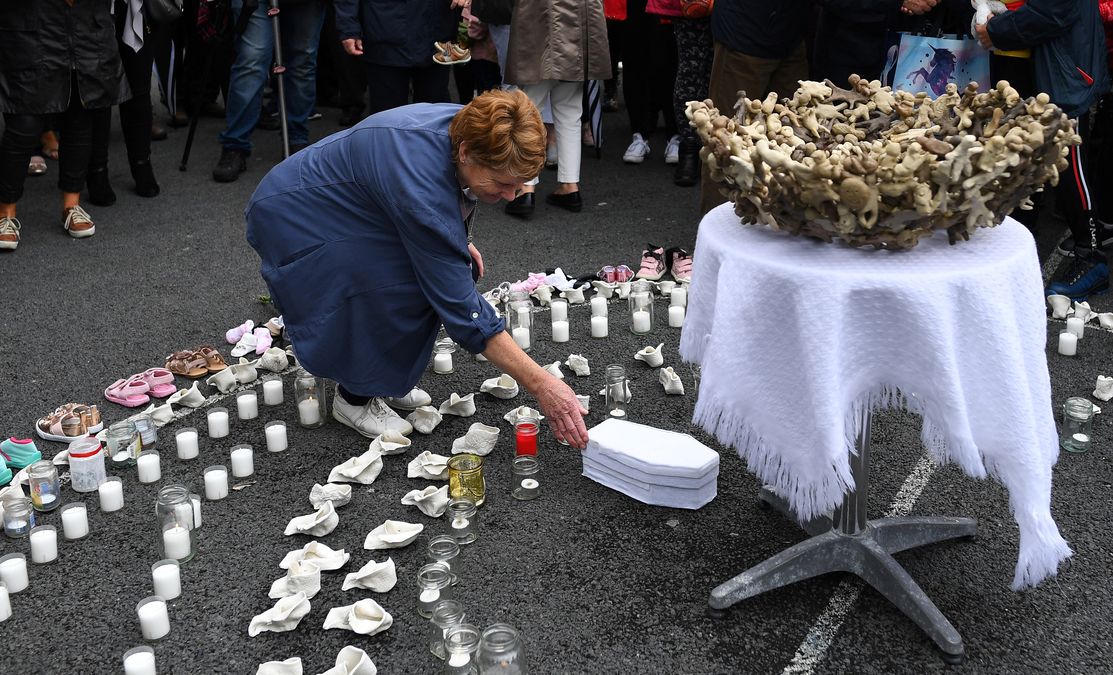 People attend a vigil at the site of the Tuam babies graveyard where the bodies of 796 babies where uncovered at a site of a former catholic home for unmarried mothers and their children in Tuam
