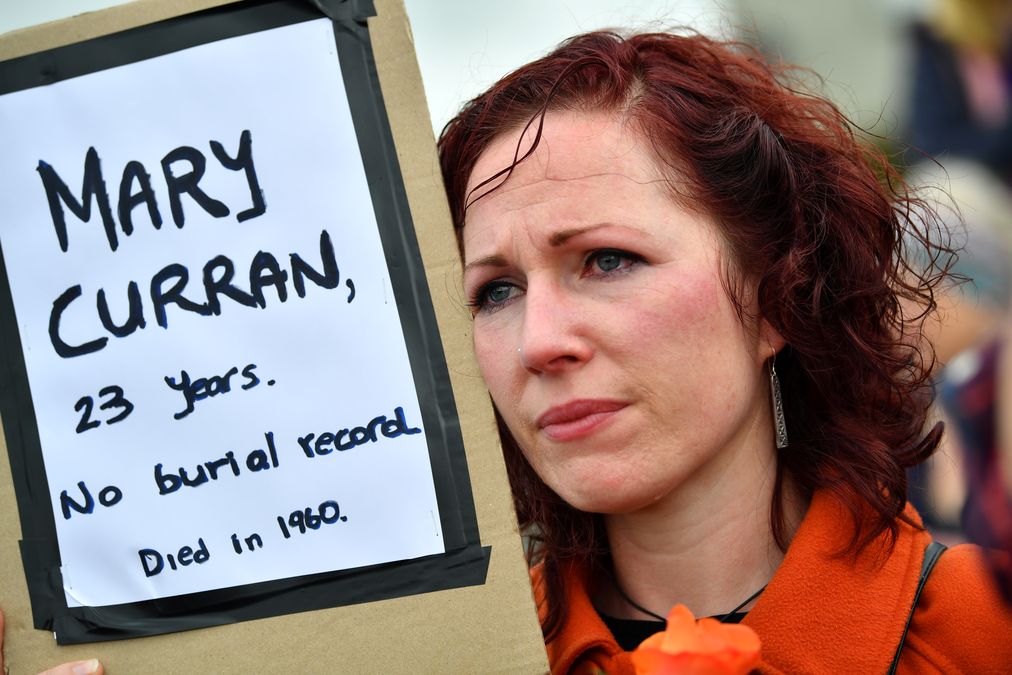 A woman attends a vigil at the site of the Tuam babies graveyard where the bodies of 796 babies where uncovered at a site of a former catholic home for unmarried mothers and their children in Tuam