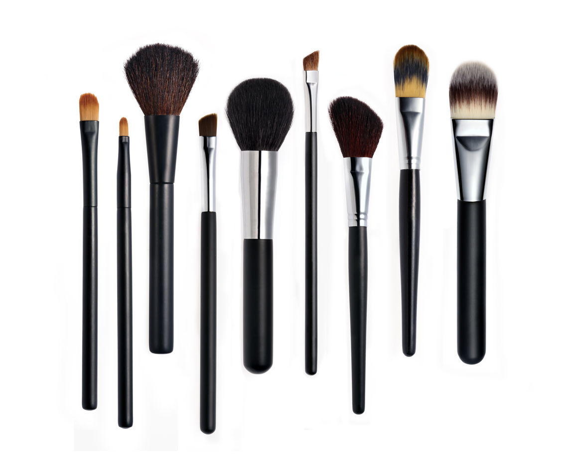 Set of various types of makeup brushes lined up in a row