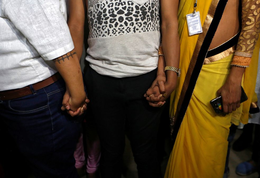 Supporters of the lesbian, gay, bisexual and transgender (LGBT) community hold hands as they wait for the Supreme Court’s verdict on decriminalizing gay sex, at an NGO in Mumbai