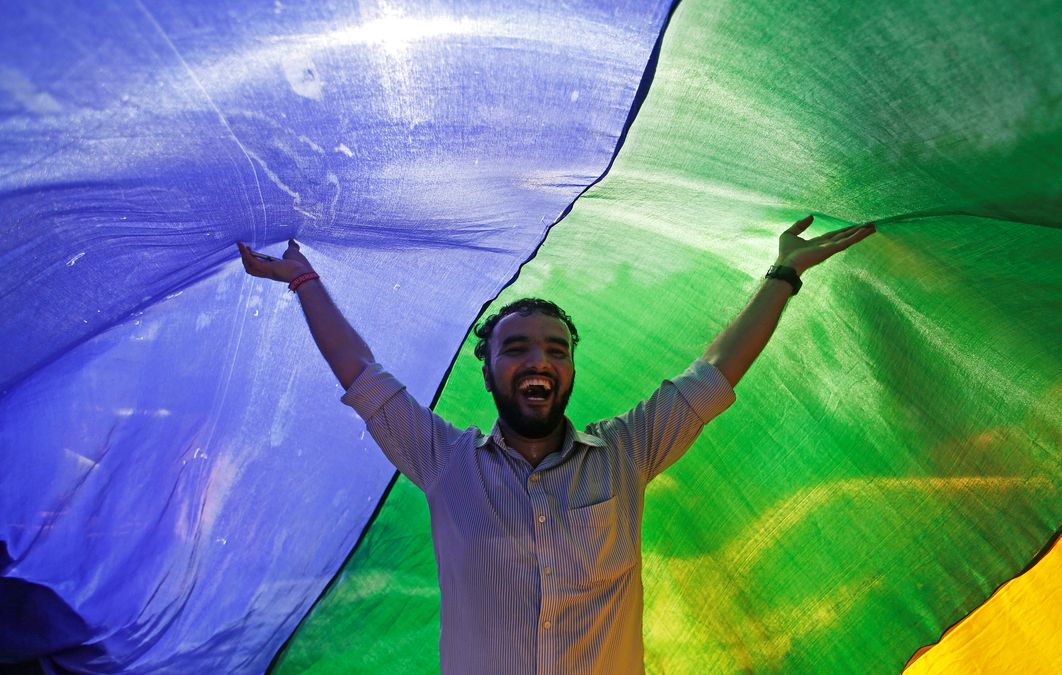 A supporter of the lesbian, gay, bisexual and transgender (LGBT) community holds a rainbow flag as he celebrates after the Supreme Court’s verdict of decriminalizing gay sex and revocation of the  Section 377 law, during a march in Mumbai