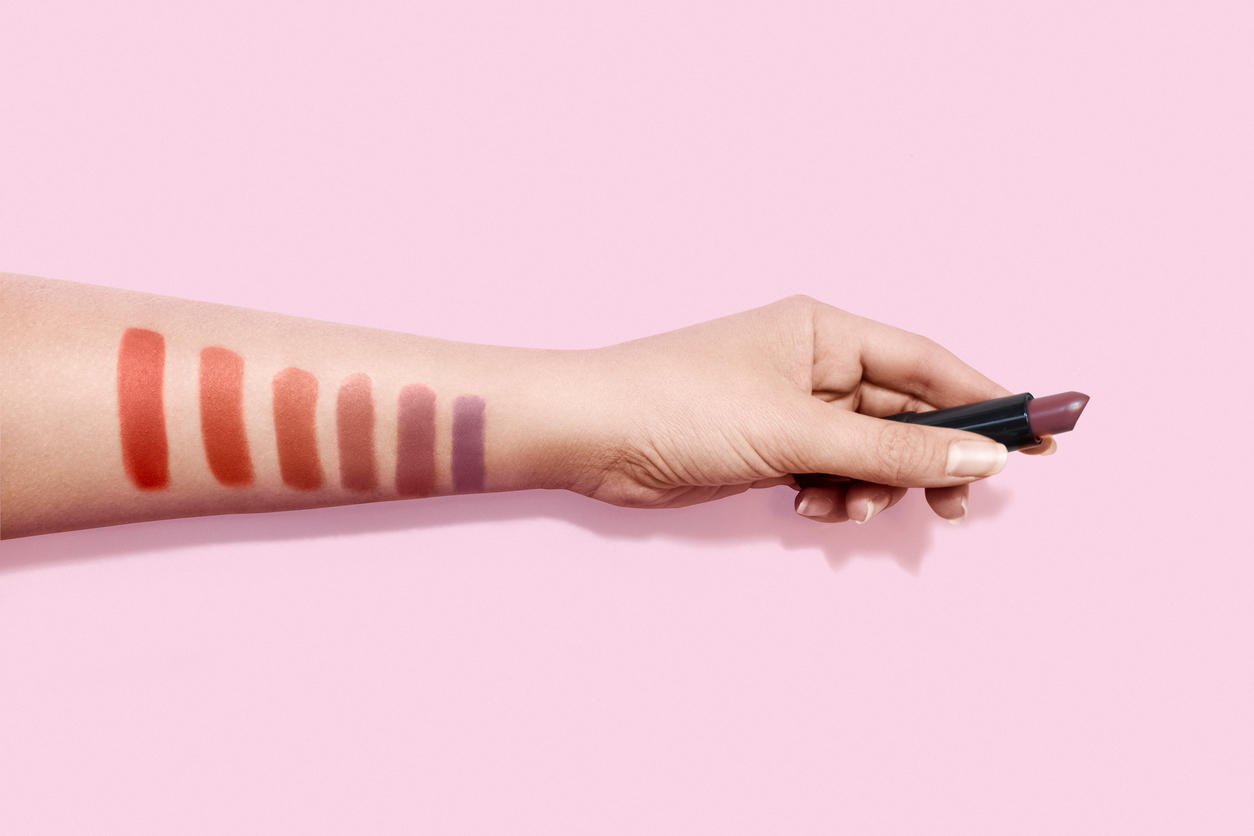 Lipstick makeup swatches on female hand holding lipstick
