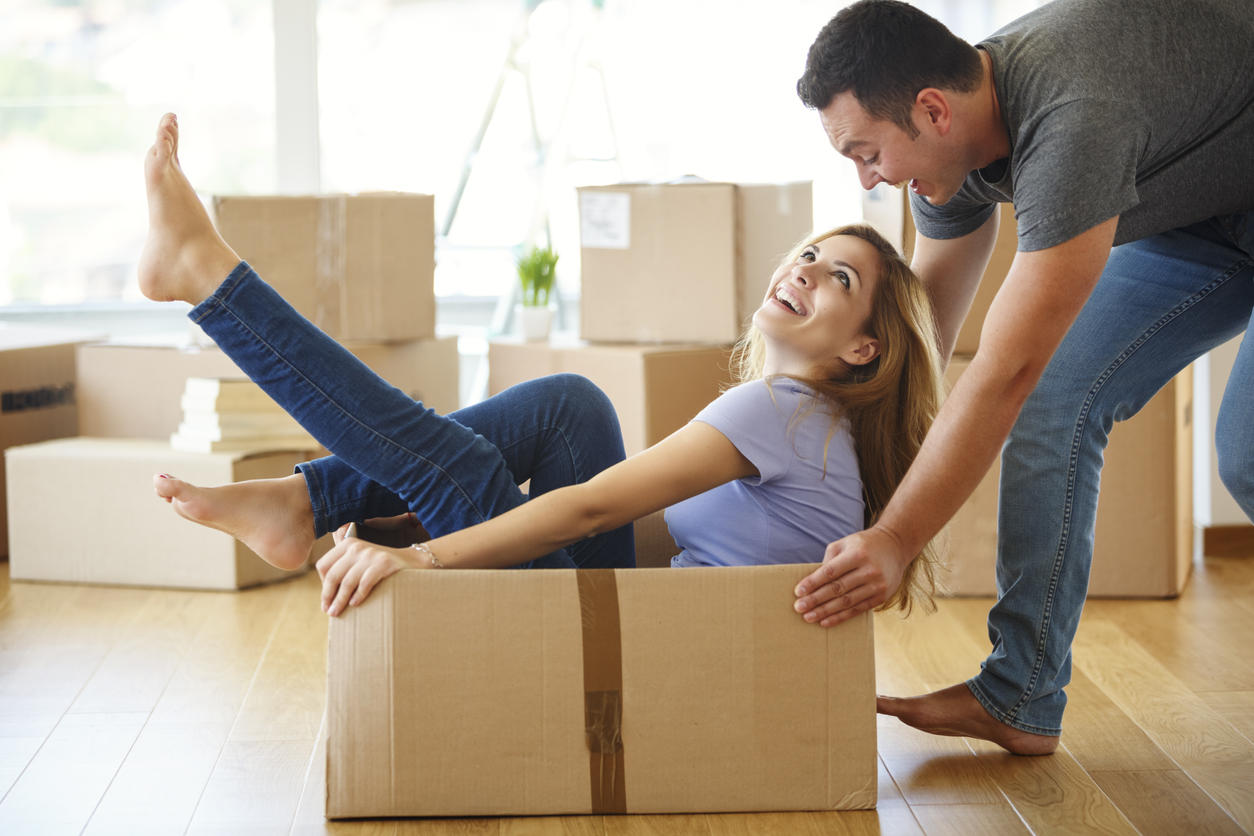 Young couple having fun while they moving into new home